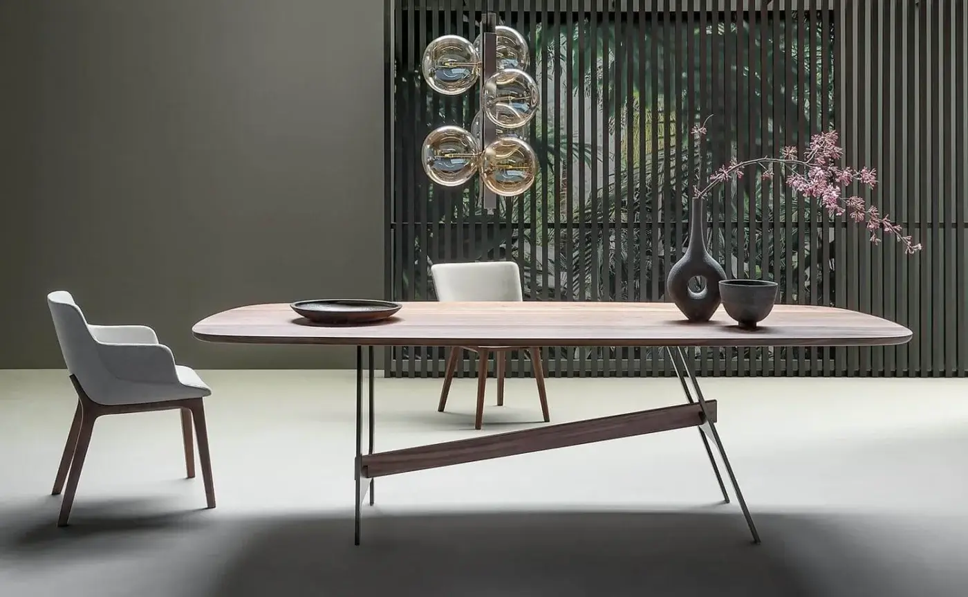 Elegant Bonaldo Slot table with warm wood top, visible grain and dark metal splayed legs connected by a matching wooden beam