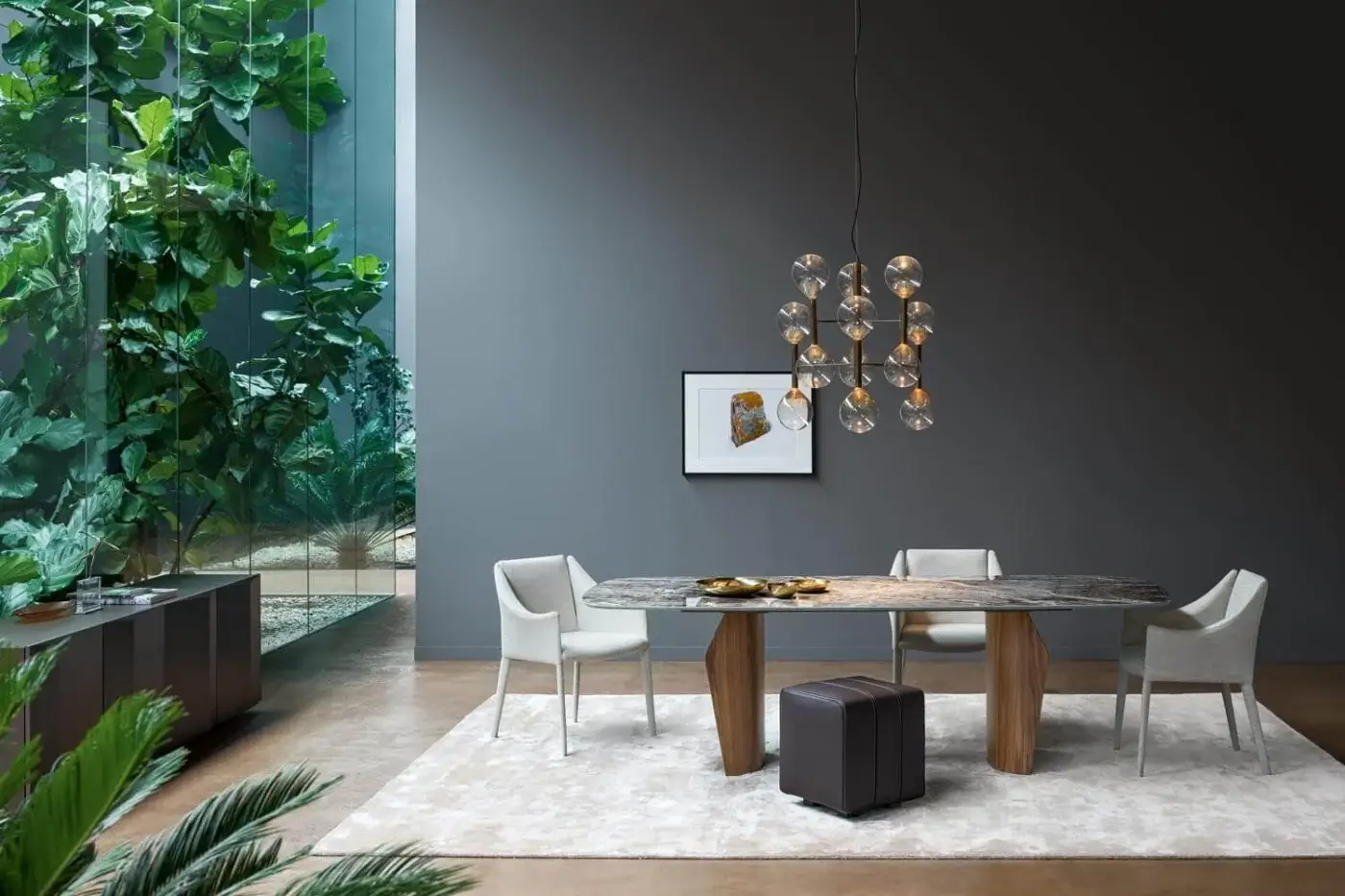 Bonaldo Flame dining table, marbled gray tabletop, walnut geometric base, with four light gray chairs, black ottoman, and amber glass chandelier.