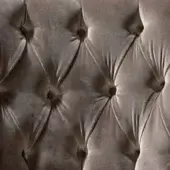 Gray velvet upholstery detail with diamond tufting and circular buttons, displaying a padded, textured surface and subtle sheen.