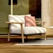 Comfortable Royal Botania Mambo Lounge chair in light textile with natural wooden frame, designed for relaxation.