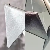Mobile sculpture with silver, blue-purple, and textured glass triangles suspended on white wires, abstract geometric composition.