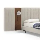 Upholstered headboard with walnut accent panel and sconce, featuring beige ribbed fabric, dark metal arm, and frosted glass shade.