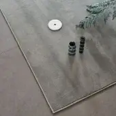 Gray textured rug with cream border, green marble cylinders, white disc, and fern sprig on gray tile floor, labeled "26 salvia."
