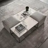 Harmonious Ditre Italia Unit coffee table with black metal base and marble-patterned stoneware top alongside light gray upholstered ottomans