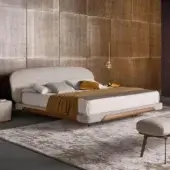 Lavish Bonaldo Olos bed with light textile upholstery and curved Canaletto Walnut wood detailing in satin finish
