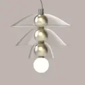 Pendant light, brushed silver, three-tiered shades with brass connectors and frosted glass bulbs against a gray-taupe backdrop.