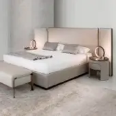 Elegant Rugiano Falcon bed with beige fabric or leather upholstery and recessed base creating a floating effect with bronze brass accents