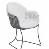 White tufted armchair with black metal frame, featuring quilted upholstery and a curved, minimalist base in a studio setting.