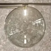 Borosilicate glass pendant light, dark bronze metal bar, Edison bulb, textured sphere, warm glow, contemporary minimalist design.