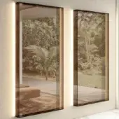 Distinguished Lago Glass Mirror with dark-toned tempered glass frame and integrated vertical lighting reflecting surrounding space