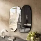 Distinguished Lago Melty mirror with overlapping organically shaped glass reflecting light and interior exterior scenes in polished darker finishes