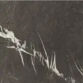 Dark grey marble stone surface with irregular white calcite veins, exhibiting a subtle granular texture and muted matte finish.