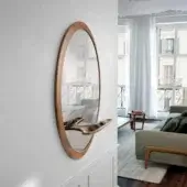 Refined Pacini & Cappellini Mirage mirror with wooden frame and natural finish, including an asymmetric light-brown shelf below