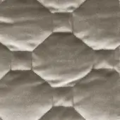 Quilted fabric texture in taupe features repeating hexagonal patterns with curved centers and angled folds, creating a soft, matte finish.