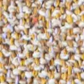 Granulated texture sample, white and mustard yellow, with lavender and orange flecks, displaying uneven particle distribution and faint text inscription.