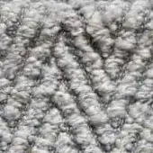 Light gray looped pile carpet texture with diagonal curving lines, soft plush fibers, and subtle tonal variations in a neutral palette.