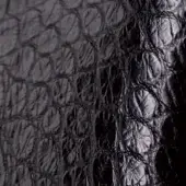 Black alligator skin texture with dense, raised ridges and irregular depressions, displaying a subtle sheen and monochromatic tone.
