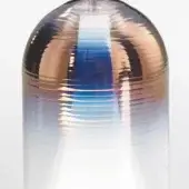 Iridescent glass cylinder from Martina collection, copper-bronze-blue gradient, horizontal ridges, studio shot, reflective surface.