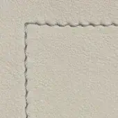 Light gray granular texture with rectangular cutout revealing layered surface, uneven particles, and roughly frayed edges under diffuse lighting.
