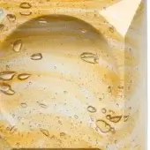 Translucent amber resin with suspended air bubbles displays a granular texture and glossy sheen, creating an organic, dynamic pattern.
