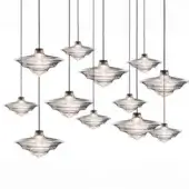 Pendant lights, clear textured glass, ridged disc shades with brass fittings, staggered silver cables, studio lighting, white background.