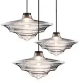 Pendant lights, clear rippled glass, disc-shaped shades with bronze hardware and black cables, layered arrangement, warm diffused glow.