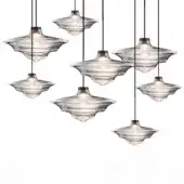 Pendant lights, rippled glass, saucer shades with flared rims, brass interiors, black cords, layered arrangement, white background.