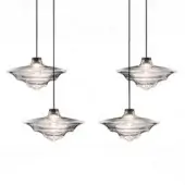 Pendant lights with ridged glass shades, clear flared form, and brushed brass fittings suspended against a white backdrop.