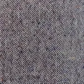 Herringbone fabric texture in deep plum with orange, blue, and cream flecks, featuring alternating diagonal weave lines and a speckled pattern.