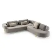 Gray roma sectional sofa with rounded form, textured upholstery, and brushed brass legs, styled with geometric pillows.