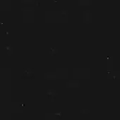 Monochromatic granular texture with irregular light gray speckling on a dark gray background, creating a muted, uniform surface pattern.