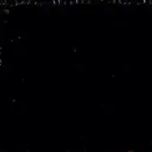 Dark abstract composition with granular texture at top and scattered bright particles, creating depth against a black background.