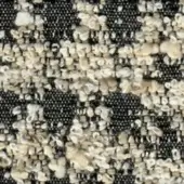 Dark charcoal gray woven fabric texture with speckled pattern of cream, beige, and tan granules creating a mottled, organic surface.
