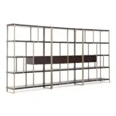 Modular bookcase, dark brown wood frame, brass metal supports, three connected units with adjustable shelves and geometric grid structure.