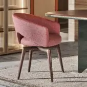 Distinguished Turri Blues armchair presents a sinuous form upholstered in textured reddish-pink textile with tapered dark wood legs
