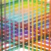 Multi-colored rod installation, acrylic-like material, grid pattern with intersecting angles, vibrant hues of green, yellow, red, purple, and blue.