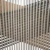 Circular screen with silver metal rods and textured brown-green natural polymer cord background, modern architectural partition.