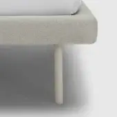 Bed side rail, light gray herringbone fabric, with cylindrical off-white leg; minimalist design, studio shot, neutral gray background.