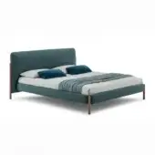 Teal upholstered bed with rectangular headboard, light wood accents, white duvet, and teal pillows, studio shot.