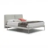 Bed base, light gray upholstery, low profile headboard with stainless steel legs and white bedding with coral accent pillow.
