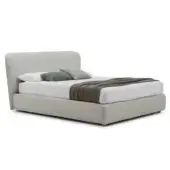 Upholstered bed with low platform, beige fabric, curved headboard, white duvet, gray throw, and two white, one green pillow arrangement.