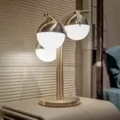 Distinguished Turri Eclipse table lamp with a satin metal structure and opaque white glass spheres suspended by tan leather straps in gold tone