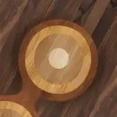 Wood bench with concentric rings, light blonde to dark brown tones, rippled grain texture, circular white center, dark wood floor.