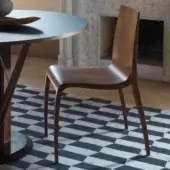 Distinguished Horm Ki chair crafted in Italy with solid wood legs and medium-brown plywood, exhibiting an embossed backrest detail