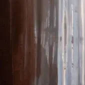 Corrugated metal surface displaying a gradient from dark brown to silvery-gray, with vertical ridges and oxidation patterns creating textural depth.