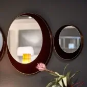Distinguished Borzalino Eclipse mirror crafted in treated brass with reddish-brown wood-like material and gold metallic accents