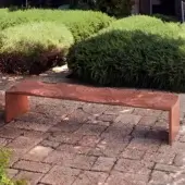 Distinctive Horm Ripples bench crafted in Italy with reddish-brown okoume wood exhibiting a circular grain pattern