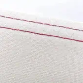 Off-white cotton or linen fabric section with two parallel lines of ruby red stitching, matte texture, even weave, neutral white background.