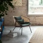 Elegant Miniforms Colony lounge chair with enveloping structure, woven rattan and dark green textile cushions with matte finish