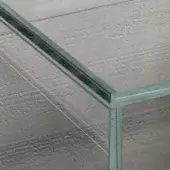 Glass table with galvanized metal frame, rectangular shape, transparent surface revealing concrete ceiling, white wires diagonally crossing.